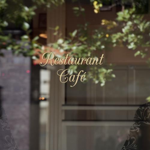 stock-photo-reflection-of-tree-and-office-building-in-signage-window-of-restaurant-117323821
